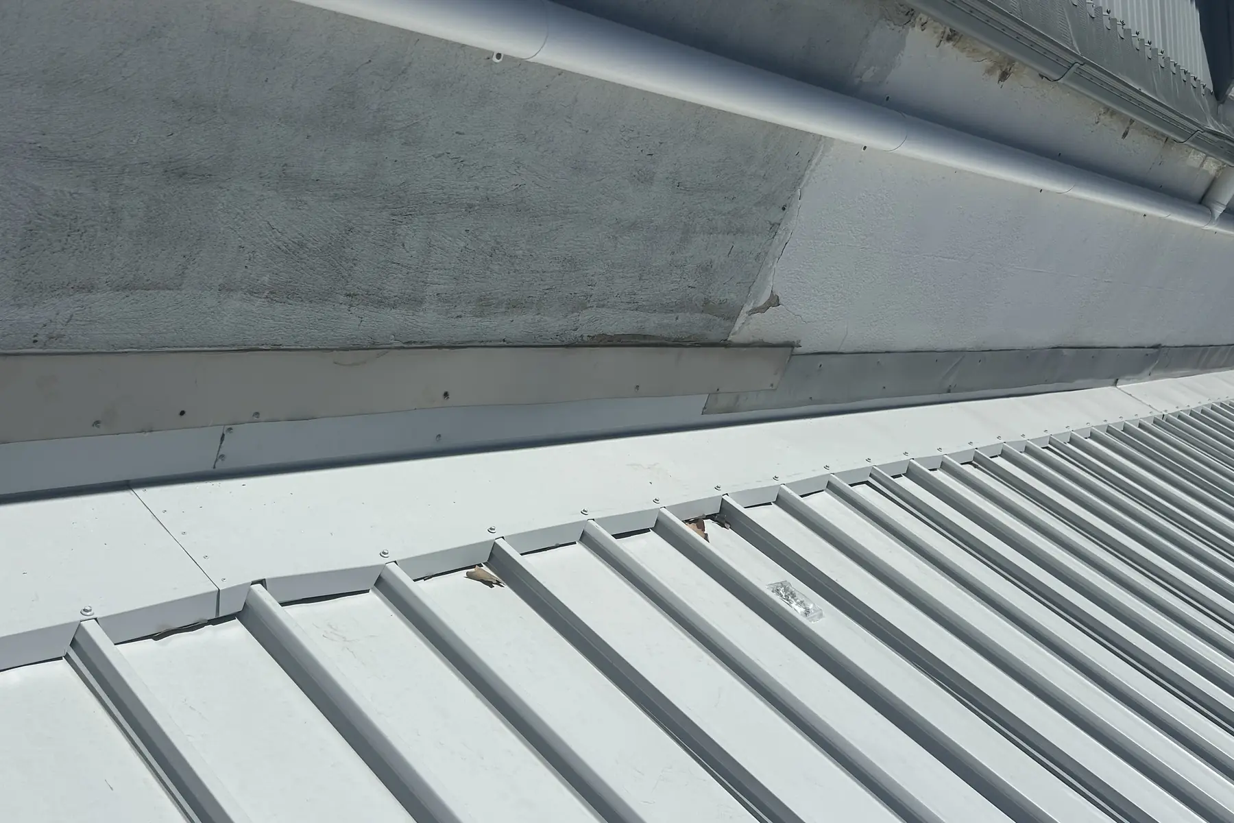 New sheeting finished up against a rendered wall, the flashing folded in along the top