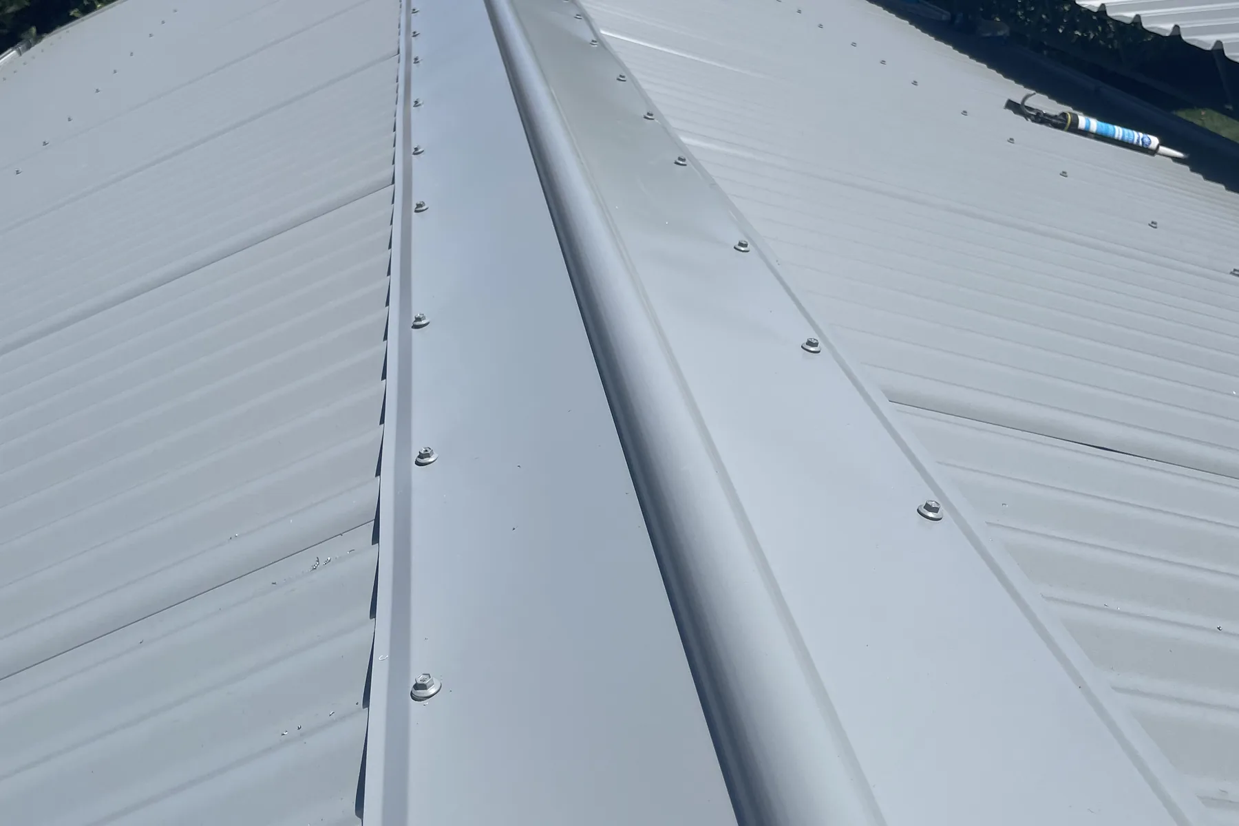 A new ridge cap and roof sheeting with the fixings set in line along the crest